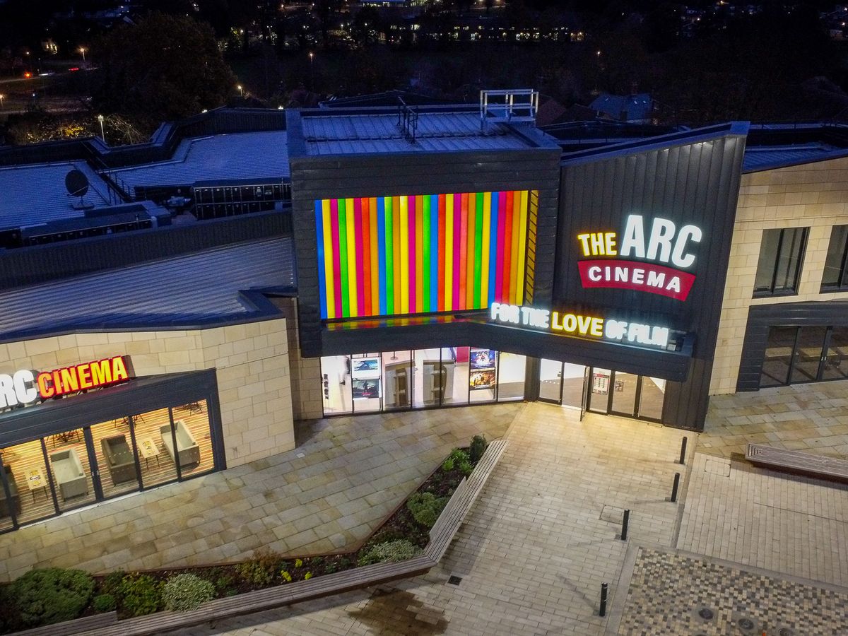 Aerial night view of a cinema building lit up
